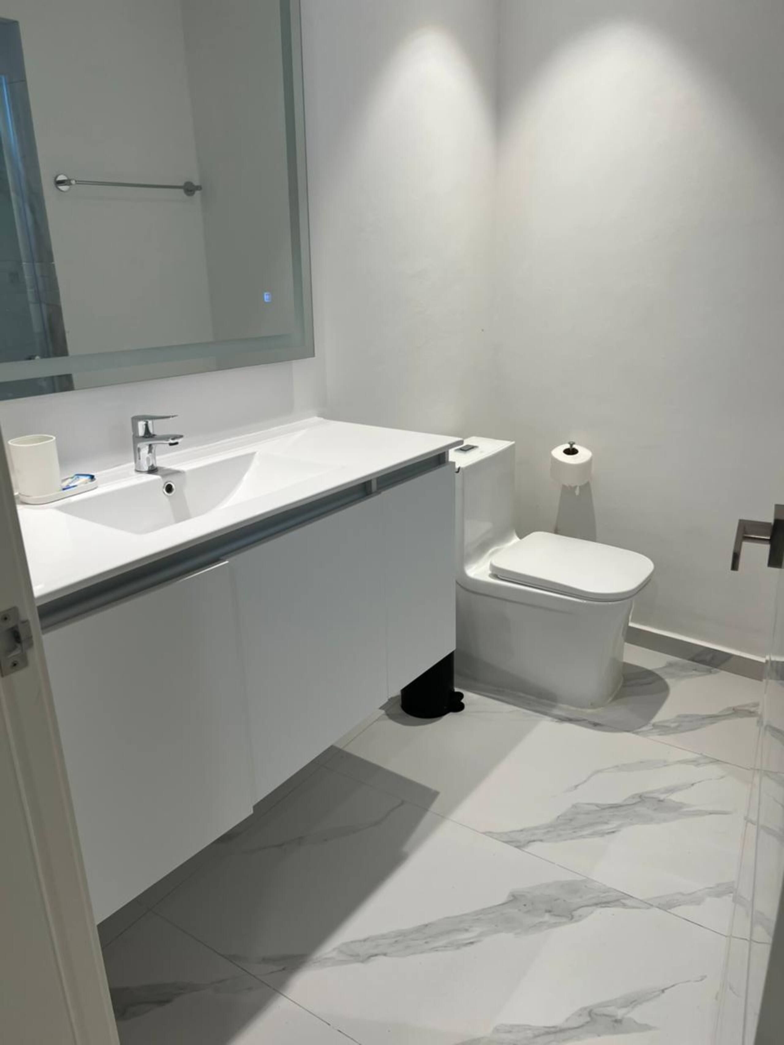 Modern bathroom with vanity and backlit mirror