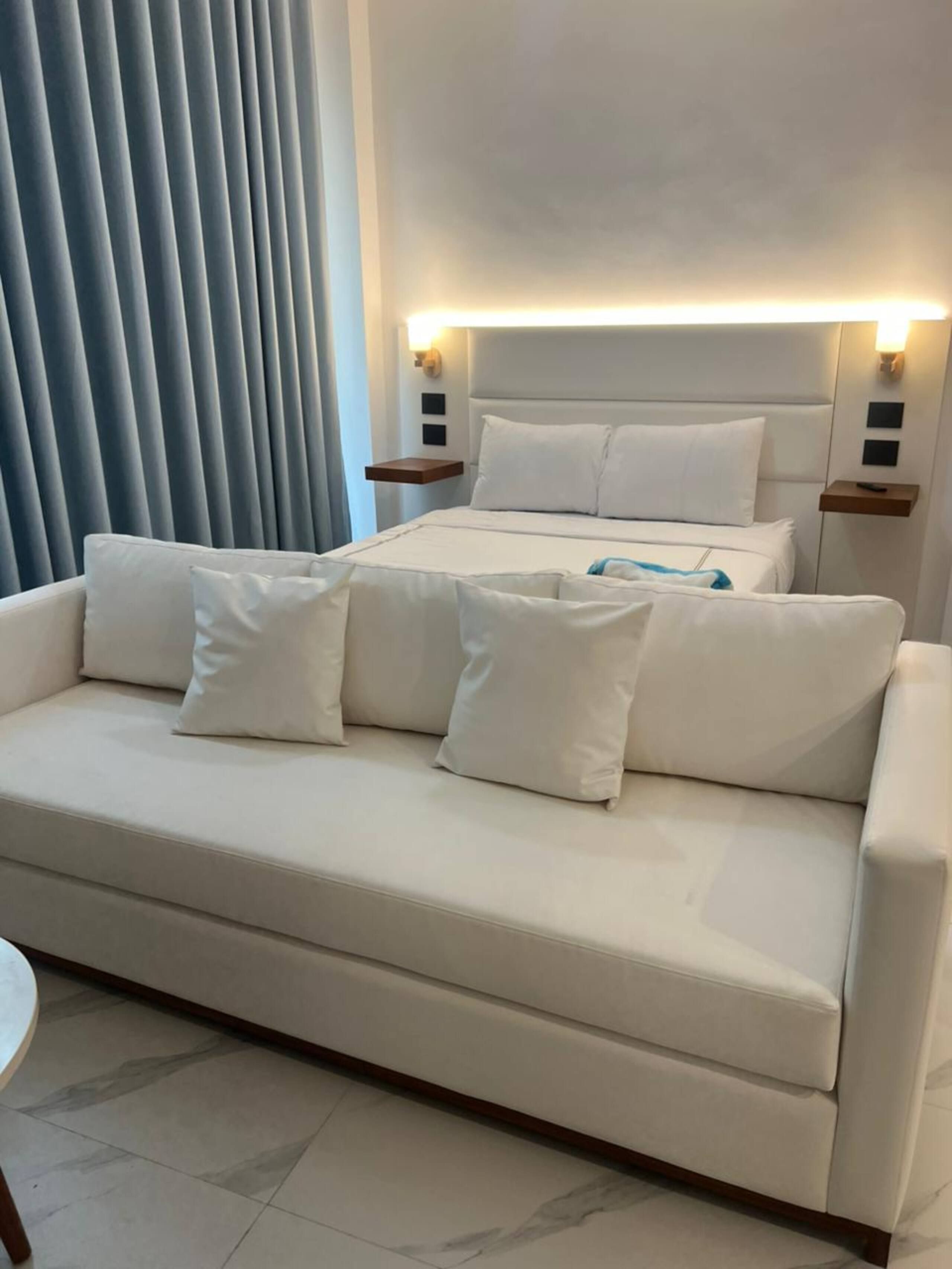 Suite with queen bed and white sofa bed