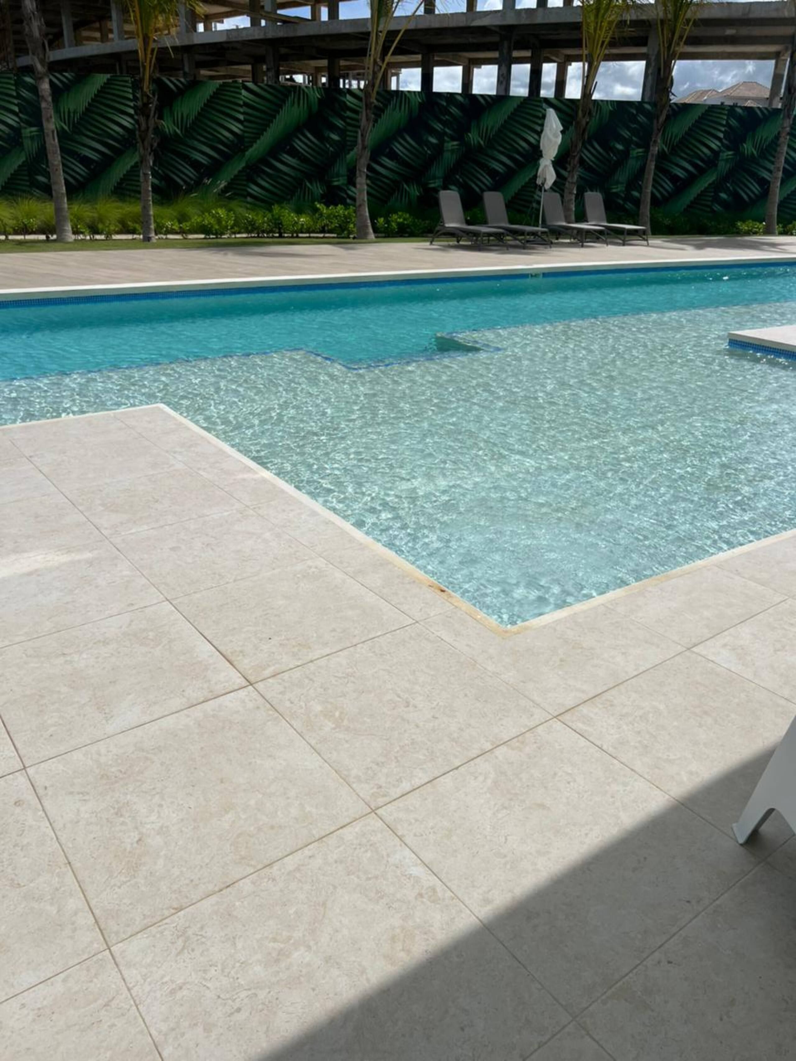 Terrace tiles meeting the pool edge, one step from the water