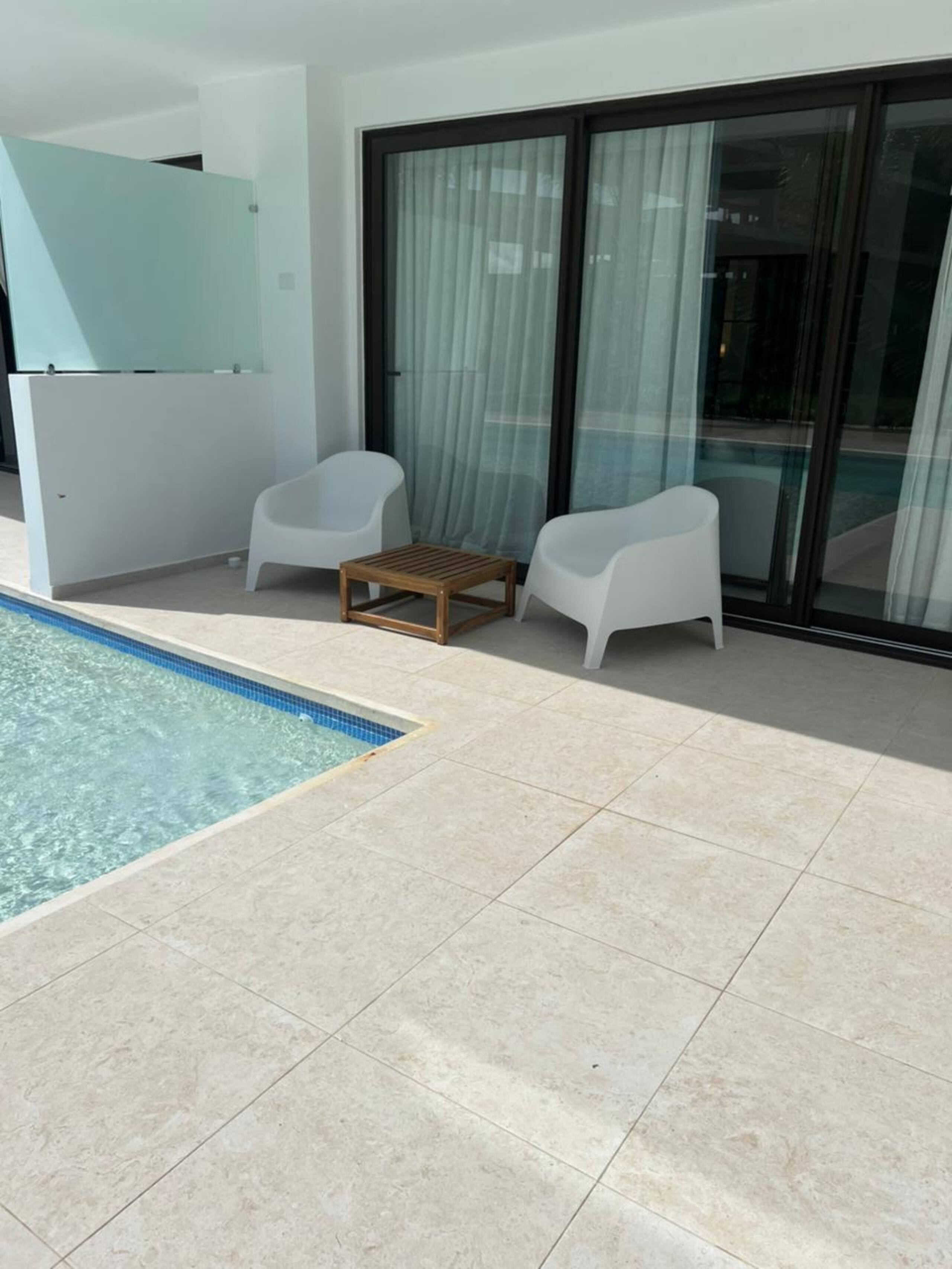The apartment’s private terrace with two lounge chairs, with the pool starting at the edge of the terrace